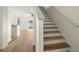 Bright staircase with wood-look flooring, white molding, and archway to living area at 568 Shoreham Ne Ct, St Petersburg, FL 33716