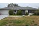 Single-story home featuring a gray roof, white exterior, and a two-car garage at 5688 Oakhurst Dr, Seminole, FL 33772