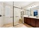 Bright bathroom featuring a glass-enclosed shower with built-in bench and double vanity at 6005 Shell Ridge Dr, Lithia, FL 33547