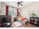 Cozy bedroom with wood floors, a ceiling fan, and a window offering natural light at 6005 Shell Ridge Dr, Lithia, FL 33547