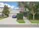 Exterior view of home with attached garage, screened in patio, driveway, and landscaped front yard at 6005 Shell Ridge Dr, Lithia, FL 33547