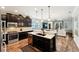 Open-concept kitchen with stainless steel appliances, dark cabinets, and view into living space at 6005 Shell Ridge Dr, Lithia, FL 33547