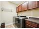 Functional laundry room with front-loading washer/dryer and upper cabinets at 6005 Shell Ridge Dr, Lithia, FL 33547