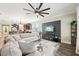 Spacious living room with a large sectional sofa, a ceiling fan, and views of the kitchen at 6005 Shell Ridge Dr, Lithia, FL 33547