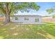 Backyard with sliding glass doors, concrete patio and mature tree at 6404 Monterey Blvd, Tampa, FL 33625