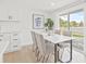 Bright dining area with white table, comfortable chairs, and sliding glass door to the backyard at 6404 Monterey Blvd, Tampa, FL 33625