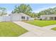 Charming home with a well-manicured lawn, paved driveway, and an attached garage at 6404 Monterey Blvd, Tampa, FL 33625