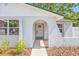 Charming front entrance with an arched doorway, white trim, and beautiful landscaping at 6404 Monterey Blvd, Tampa, FL 33625