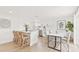 Modern kitchen with white cabinets, stainless steel appliances, a breakfast bar, and an adjacent dining area at 6404 Monterey Blvd, Tampa, FL 33625