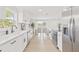 Long, bright kitchen with stainless steel appliances, white cabinets, and an open floor plan at 6404 Monterey Blvd, Tampa, FL 33625