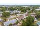 Aerial view of a residential area with homes, lush trees, and nearby streets; includes a fire pit, landscaping, and potential pool views at 6698 35Th N Ave, St Petersburg, FL 33710