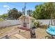 Charming backyard featuring a shed with a decorative blue swing and well maintained lawn and white vinyl fence at 6698 35Th N Ave, St Petersburg, FL 33710
