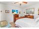 Inviting bedroom featuring wood floors, ceiling fan, large mirror, and beach themed art at 6698 35Th N Ave, St Petersburg, FL 33710