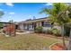Charming home featuring a welcoming front yard with vibrant plants, a decorative wooden screen, and a cozy porch with rocking chairs at 6698 35Th N Ave, St Petersburg, FL 33710