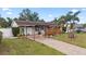 Inviting house with mature trees, well-maintained landscaping, and a covered driveway at 6698 35Th N Ave, St Petersburg, FL 33710