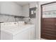Bright laundry room featuring a full-sized washer and dryer and shelving for organized storage at 6698 35Th N Ave, St Petersburg, FL 33710