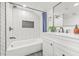 Updated bathroom featuring a tiled tub, modern vanity, and stylish mirror at 7 Hamilton Heath Dr, Tampa, FL 33604