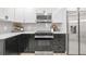 Modern kitchen includes stainless steel appliances, gray backsplash, and white upper cabinets at 7 Hamilton Heath Dr, Tampa, FL 33604