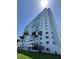 Exterior shot of the building showing landscaping, palm trees and glass windows from a low angle on a sunny day at 7200 Sunshine Skyway S Ln # 2E, St Petersburg, FL 33711