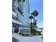 Exterior view of condo building surrounded by palm trees and a waterfront walkway at 7200 Sunshine Skyway S Ln # 2E, St Petersburg, FL 33711