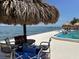 Relaxing poolside scene with lounge chairs, umbrellas, and views of the sea and nearby pier at 7200 Sunshine Skyway S Ln # 2E, St Petersburg, FL 33711