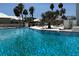 Condo community pool with lounge chairs, tiki huts, direct sunlight and palm trees at 7200 Sunshine Skyway S Ln # 2E, St Petersburg, FL 33711