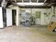 Unfinished basement with washer, dryer, water heater, and utility sink near to an open doorway at 888 Forest Glen Rd, Clearwater, FL 33765