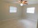 A bright bedroom featuring neutral walls, tile flooring, and dual windows with blinds at 888 Forest Glen Rd, Clearwater, FL 33765