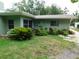 The home's exterior features a well-manicured lawn, mature landscaping, and large windows at 888 Forest Glen Rd, Clearwater, FL 33765