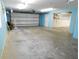 Large garage with concrete floor, white overhead door, and blue walls at 888 Forest Glen Rd, Clearwater, FL 33765