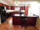 Traditional kitchen with wood cabinets, black appliances, and a granite countertop island with bar seating at 888 Forest Glen Rd, Clearwater, FL 33765