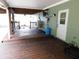 View of covered patio with stained wood flooring and painted concrete walls at 888 Forest Glen Rd, Clearwater, FL 33765