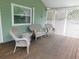 Relax on this covered side porch with wicker seating to enjoy a cool breeze and enjoy the outdoors at 888 Forest Glen Rd, Clearwater, FL 33765