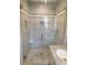 A modern shower features stylish gray tile, a glass door, and a built-in niche for toiletries at 888 Forest Glen Rd, Clearwater, FL 33765