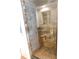 A modern shower features stylish neutral stone tile, a glass door, and a built-in niche for toiletries at 888 Forest Glen Rd, Clearwater, FL 33765