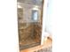 A modern shower features stylish neutral stone tile, a glass door, and a built-in niche for toiletries at 888 Forest Glen Rd, Clearwater, FL 33765