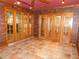 A brick sunroom has tile flooring, a ceiling fan, and glass doors that fill the room with natural light at 888 Forest Glen Rd, Clearwater, FL 33765