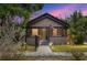 Charming single-story home with inviting front porch, soft lighting, and well-kept landscaping at dusk at 931 28Th N Ave, St Petersburg, FL 33704