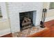 Close-up of the fireplace featuring painted white brick and a decorative tile hearth at 931 28Th N Ave, St Petersburg, FL 33704