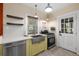 Galley kitchen with stainless steel sink, modern appliances, and custom shelving at 931 28Th N Ave, St Petersburg, FL 33704
