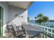 Enjoy waterfront views from this balcony featuring outdoor seating, a table and a charming coastal setting at 9939 1St E St, Treasure Island, FL 33706