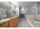 Bathroom features a large shower, jetted tub, double sinks, and wood cabinets at 9939 1St E St, Treasure Island, FL 33706