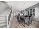 Open dining room with a grand table, grey chairs, modern lighting, with stairs and kitchen views at 9939 1St E St, Treasure Island, FL 33706
