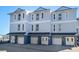 Three-story townhome featuring private garages and balconies, offering modern coastal living at 9939 1St E St, Treasure Island, FL 33706