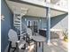 Relaxing covered patio with a hot tub, chairs, spiral staircase, and tranquil waterfront views at 9939 1St E St, Treasure Island, FL 33706