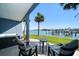 Scenic patio with a hot tub, comfortable seating, palm trees, and a view of the serene waterfront at 9939 1St E St, Treasure Island, FL 33706