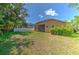 Wide-open backyard featuring green grass, a screened in lanai, and a white fence at 10212 Holland Rd, Riverview, FL 33578