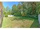 Well-maintained back yard with lush greenery, mature trees, and a white fence at 10212 Holland Rd, Riverview, FL 33578