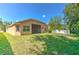 Large backyard featuring lush green grass, mature trees, and a screened-in patio at 10212 Holland Rd, Riverview, FL 33578