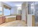 Bright bathroom featuring a soaking tub with tile surround, a walk-in shower, and double vanities at 10212 Holland Rd, Riverview, FL 33578